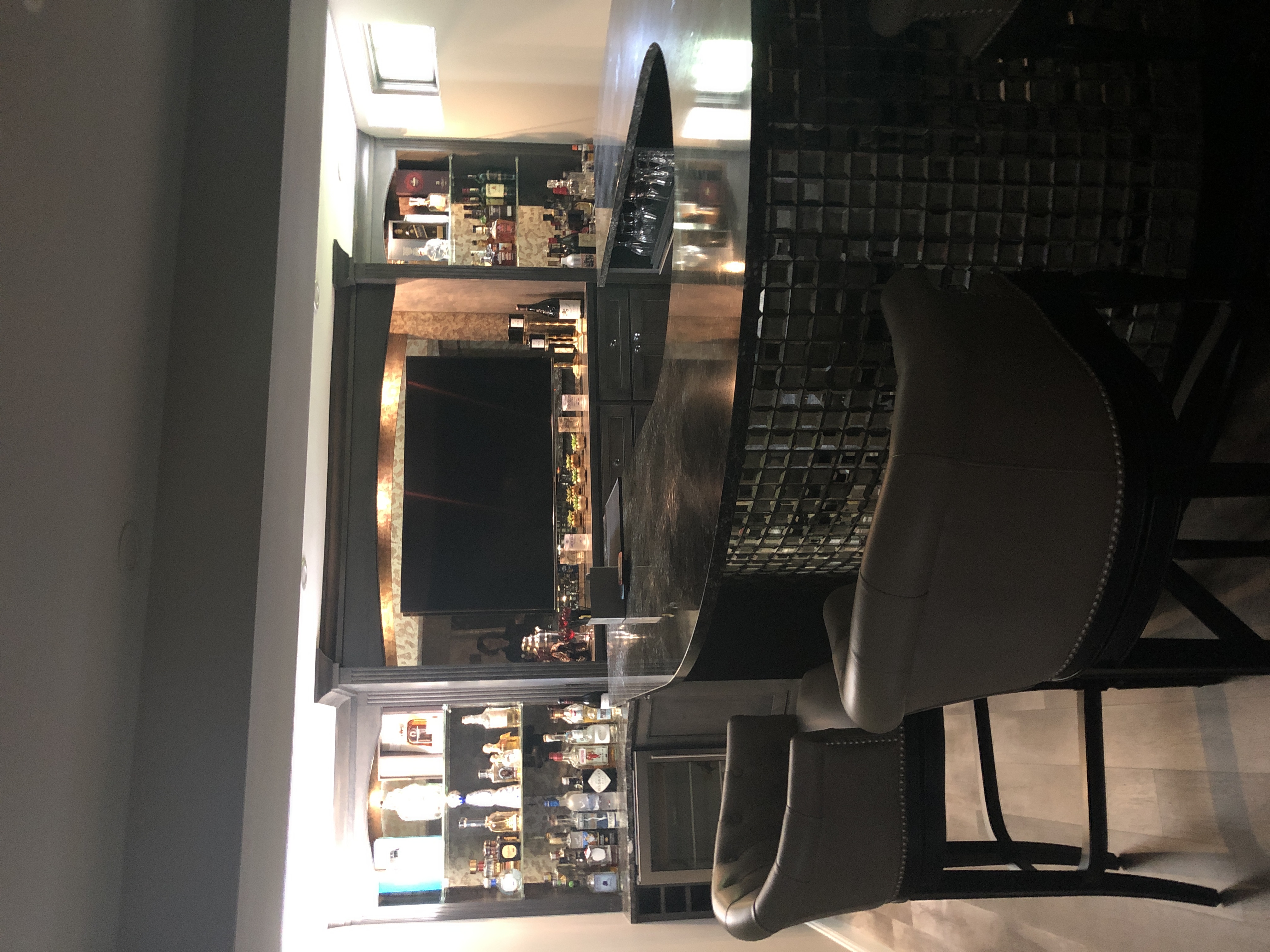 A large U shaped bar, with a black counter top and mirrored side