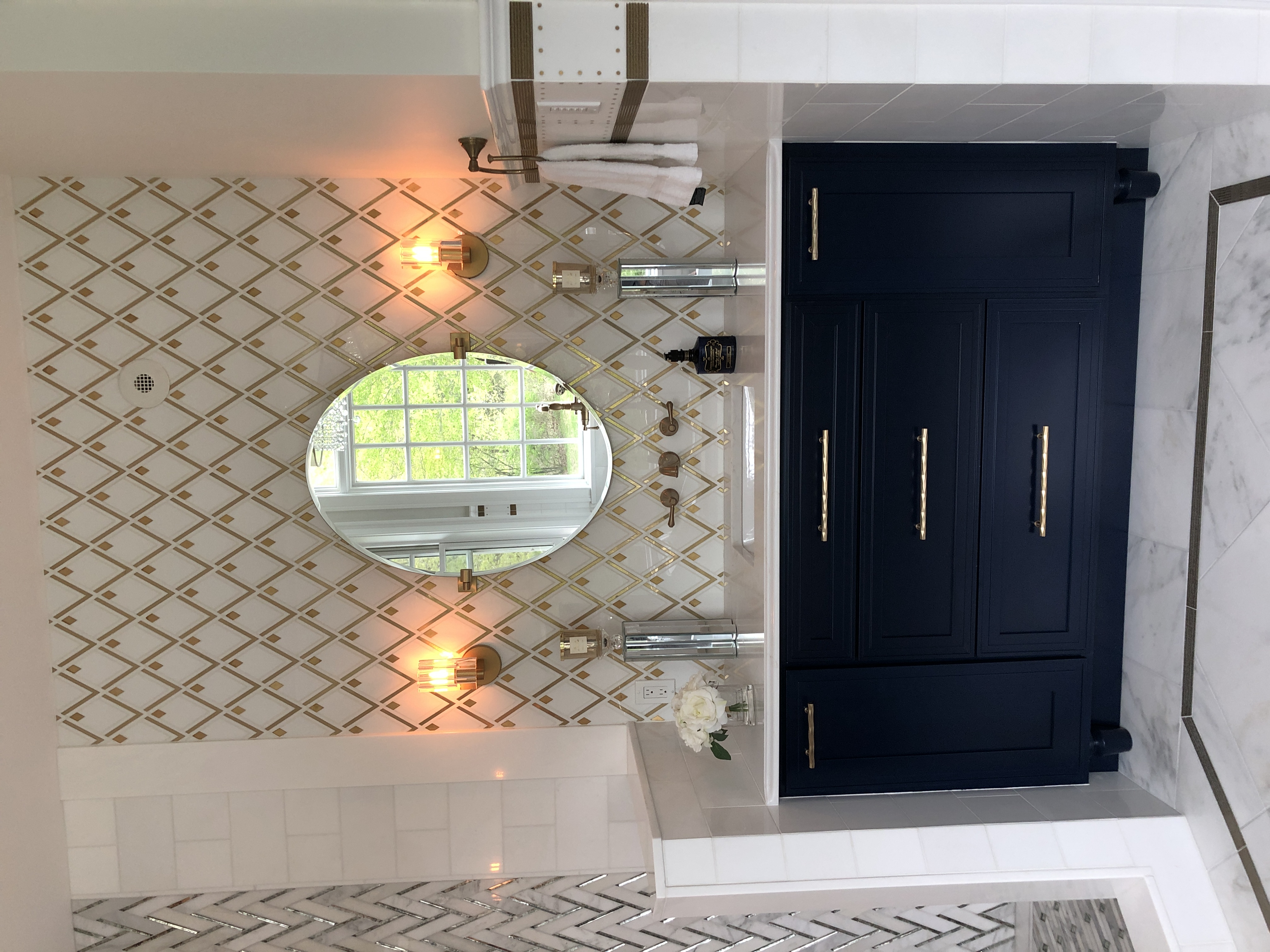 A single sink vanity with a golden diamond shaped pattern above it