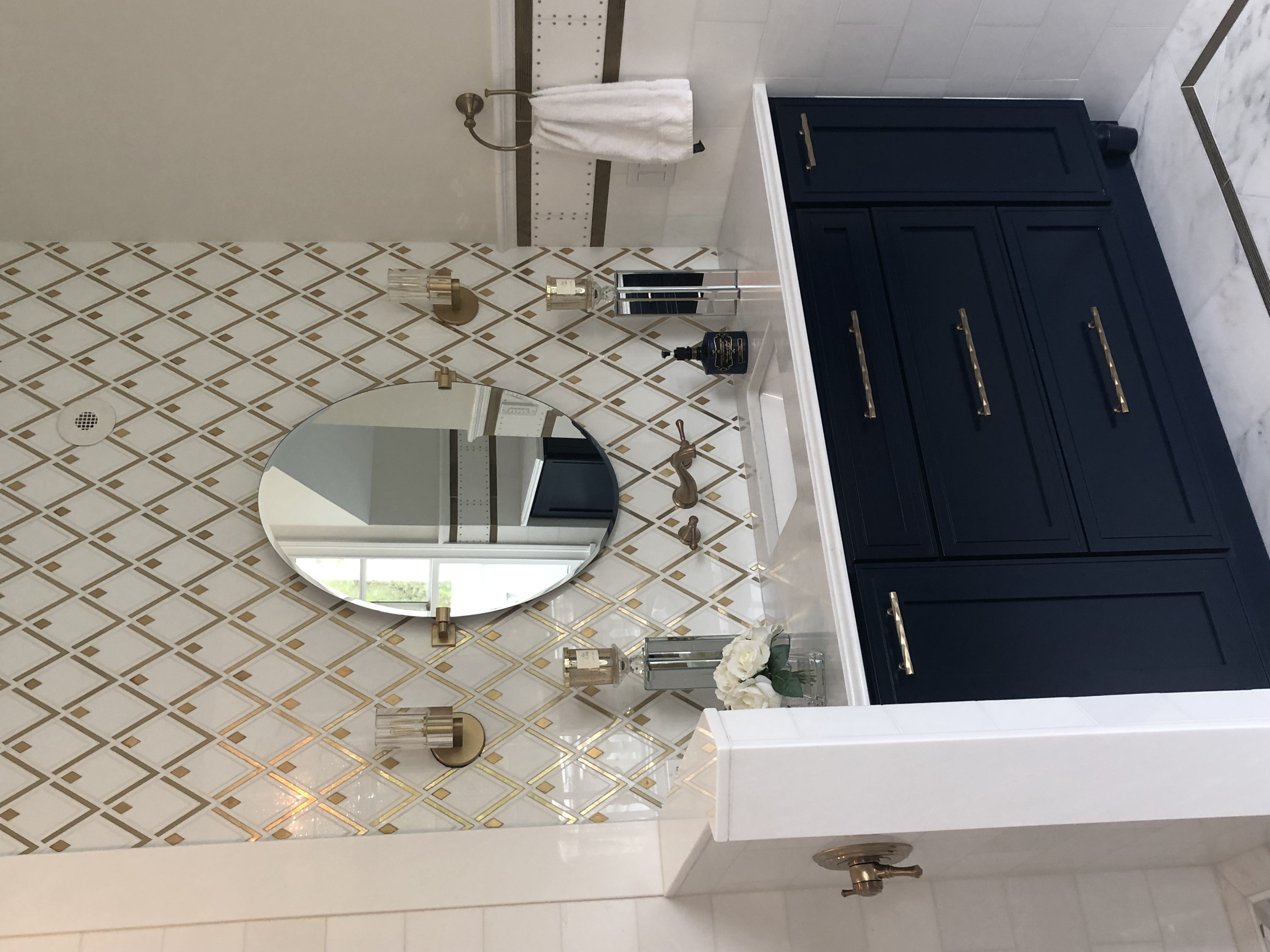 A single sink vanity with a golden diamond shaped pattern above it