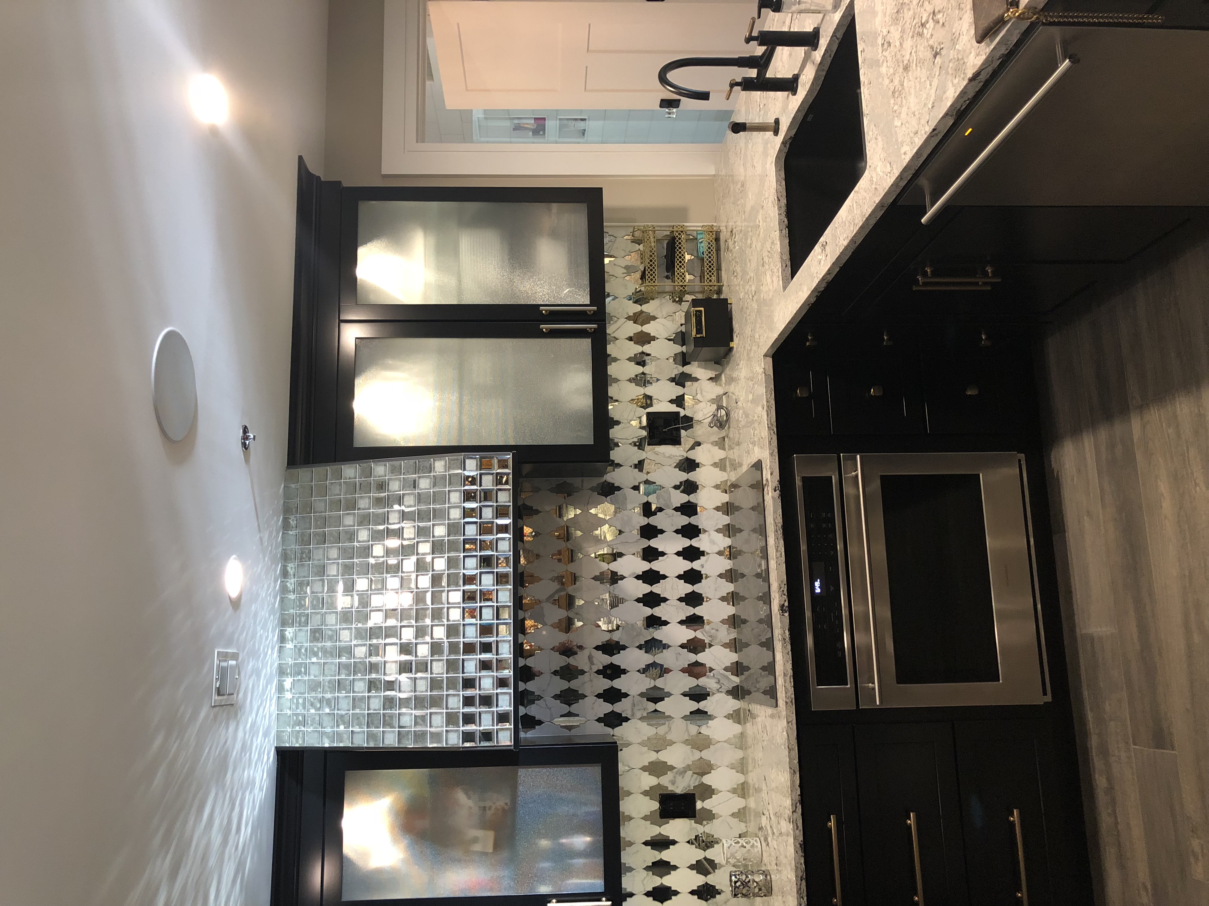 The kitchen oven with mirrored backsplash and range hood