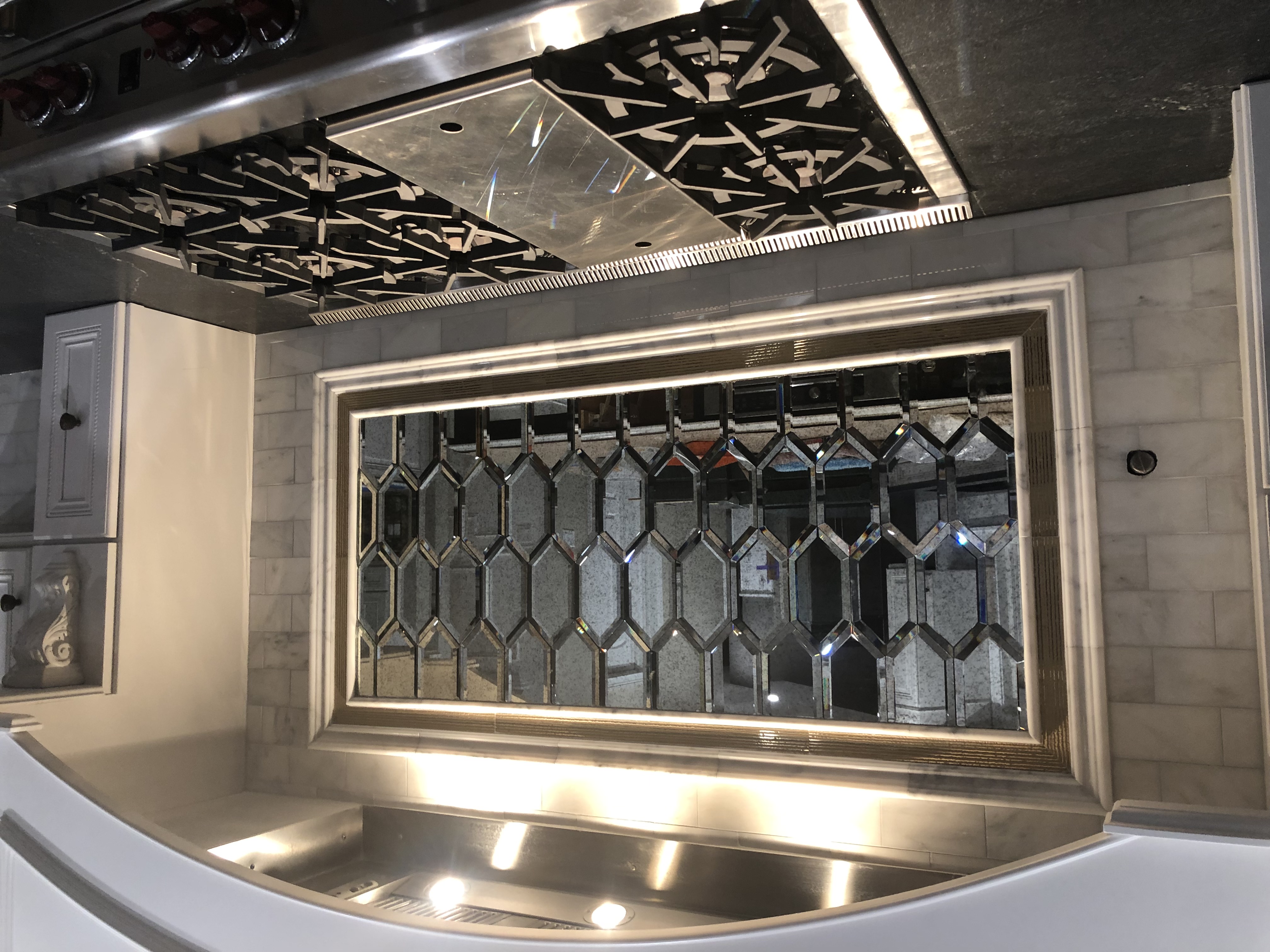 Closeup of mirrored back splash above stove